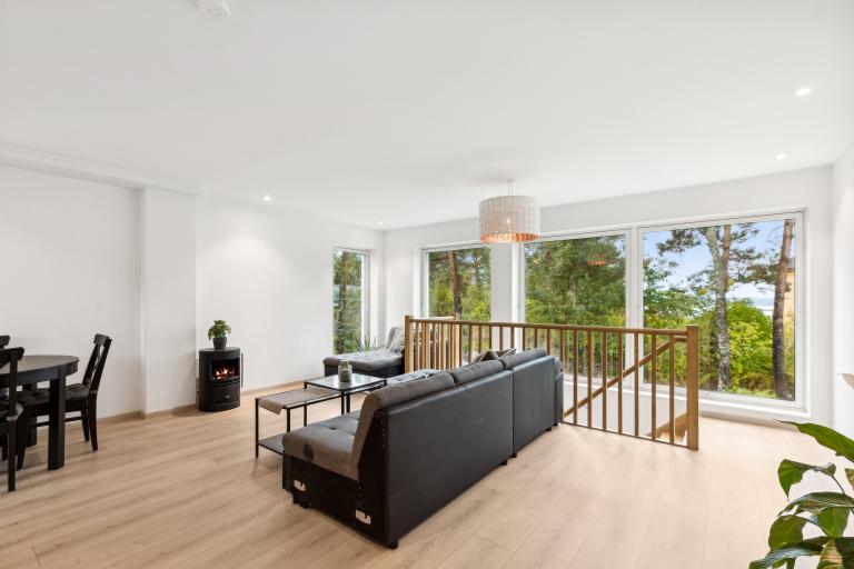 Stor stue med sjøgløtt fra store vinduer med screens