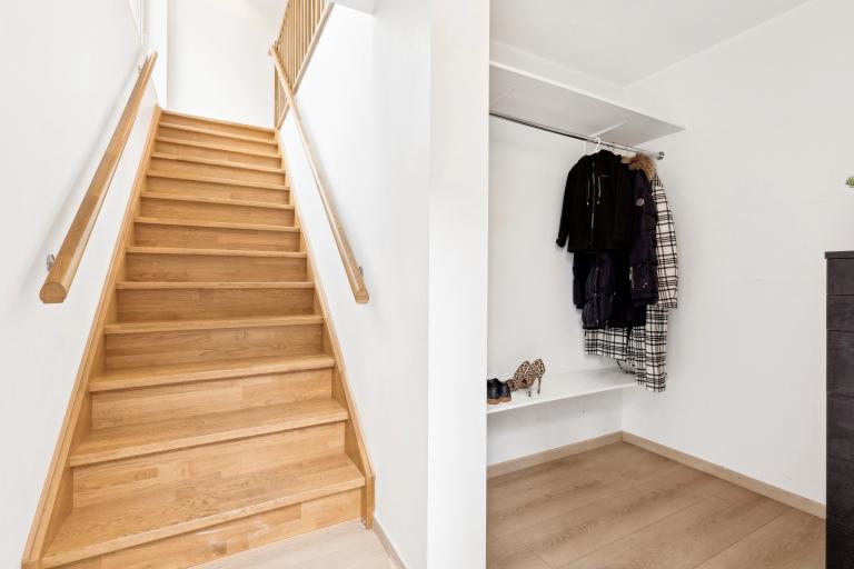 Inngangsparti i leiligheten med trapp og plass til å henge fra seg yttertøy