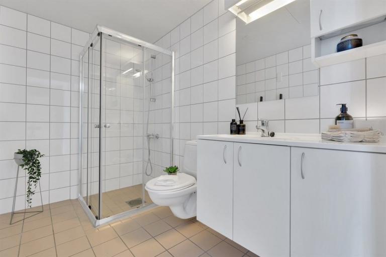 Romslig bad/toalett med vaskemaskin og tørketrommel.