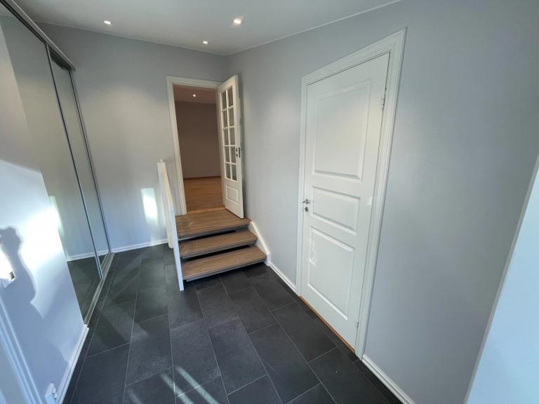 Romslig gang med oppbevaringsplass/skyvedørsgarderobe.