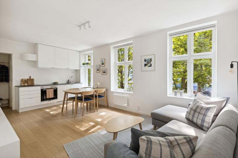 Moderne kjøkken med integrert oppvaskmaskin, stekeovn, platetopp og stort kombiskap.