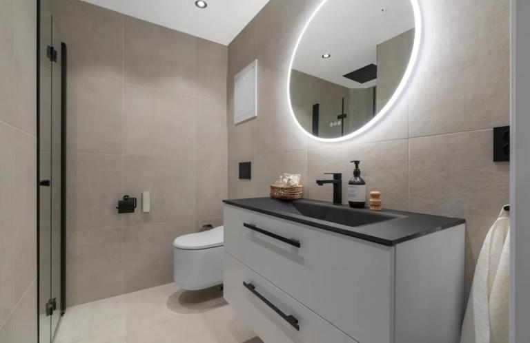 Bad med vaskemaskin, tørketrommel, spyletoalett og regndusj