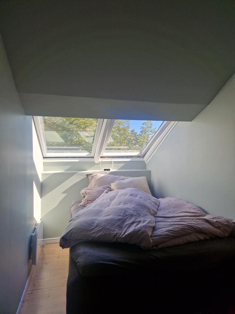 Soverom 1 med lystette gardiner og klesskap.