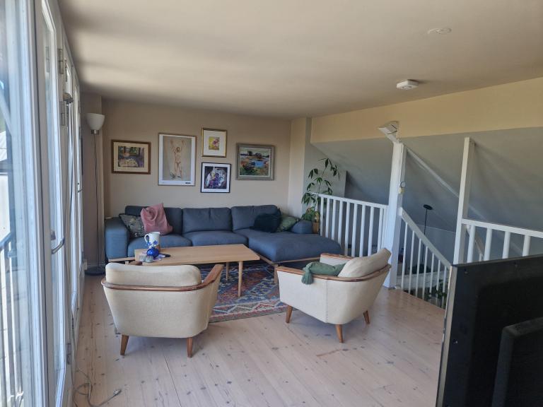 Stue med mye lys og utsikt.