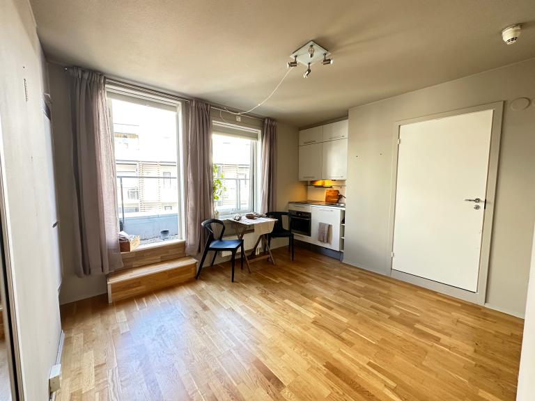 Ballongdør og vindu ut til stille bakgård. Effektivt kjøkken med induksjonstopp, kombiovn (mikro og ovn i ett), halv oppvaskmaskin, vask og mye oppbevaring. Full størrelse kjøleskap med fryser til venstre for balkongdør.