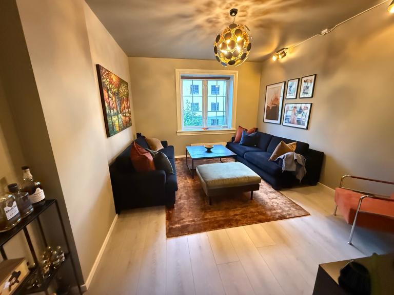 Romslig stue med to sofaer, tv og tv-benk