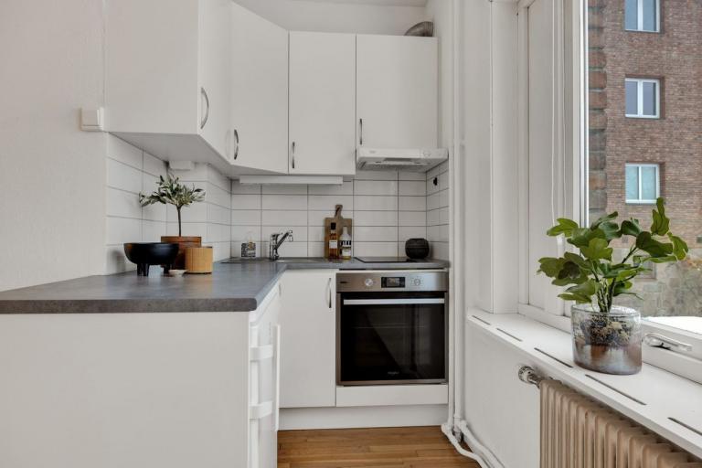 Kjøkken med hvitevarer, oppvaskmaskin, stekeovn, platetopp, kjøleskap, vannkoker, annet utstyr.