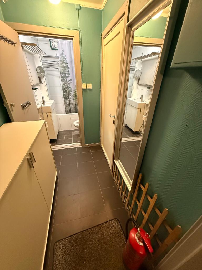 Praktisk entré med lite garderobeskap, speil og direkte tilgang til bad og stue. Flislagt gulv med varme og god plass til sko og yttertøy.