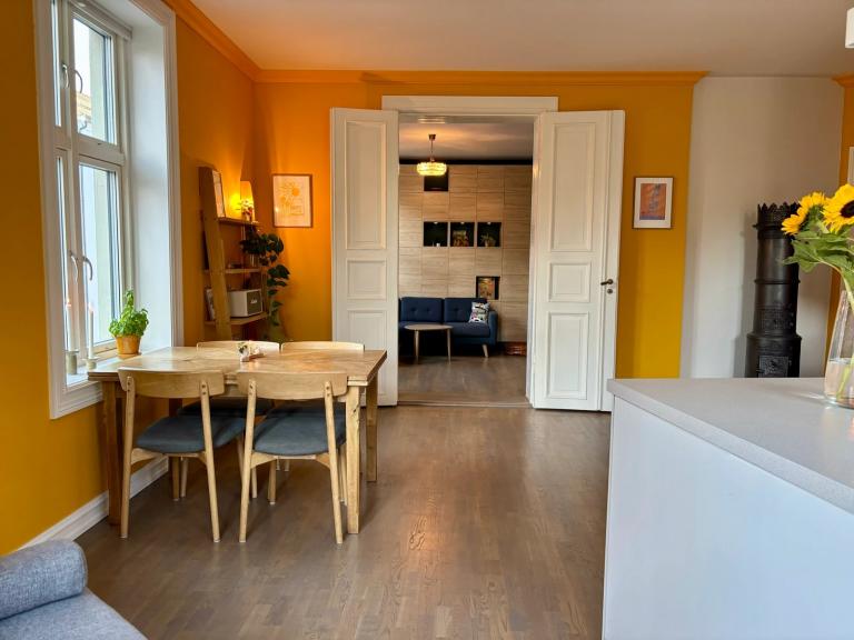 Doble orginale dører åpner opp mellom kjøkken og stue, og skaper et kjøkken-alrum. Leilighetens midtpunkt.