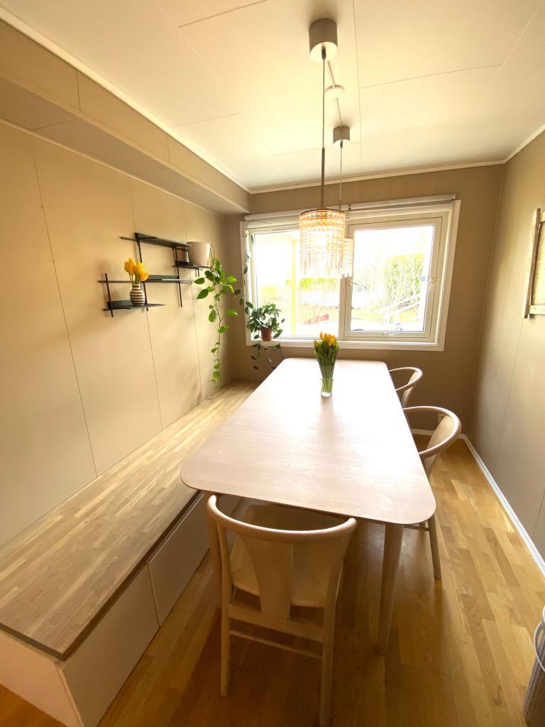 Romslig spiseplass med oppbevaringsbenk.