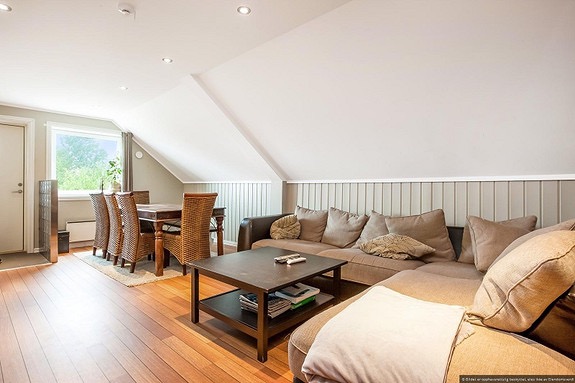 Stor stue med plass til spisestue og sofagruppe.